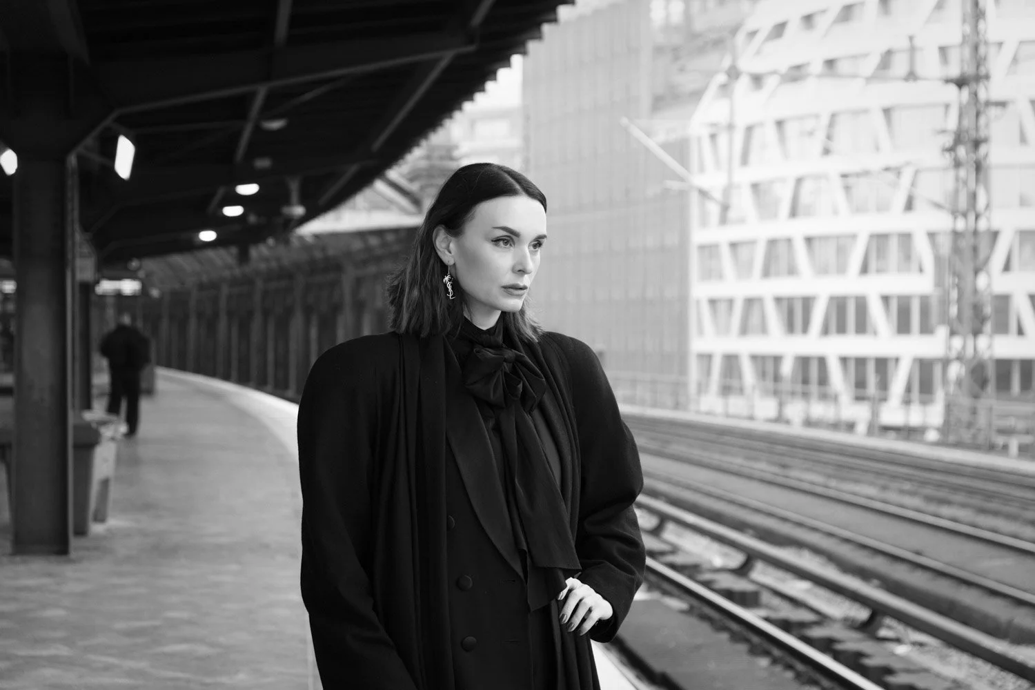 Stylish figure at train station platform.